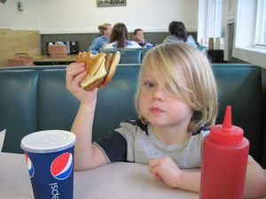 Kid_eating_veggie_burger_by kellyhogaboom in flickr (CC BY-SA 2.0)